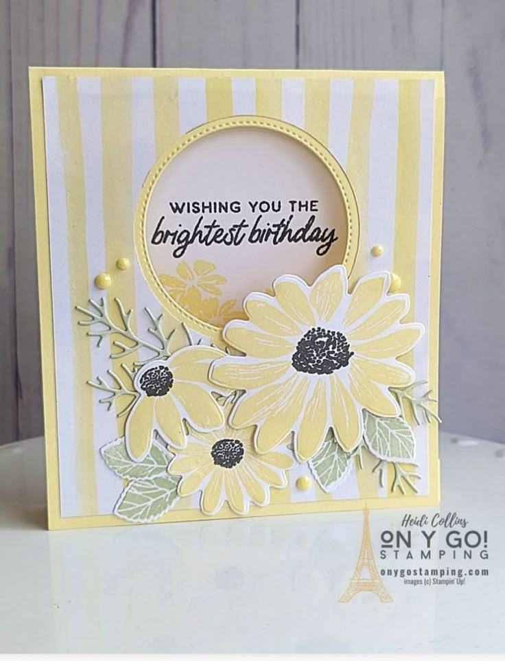 a yellow and white card with flowers on it