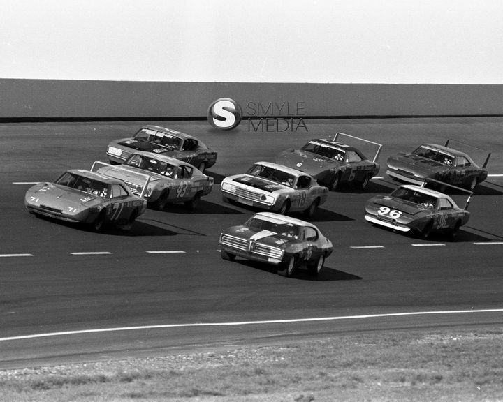 a group of cars driving down a race track