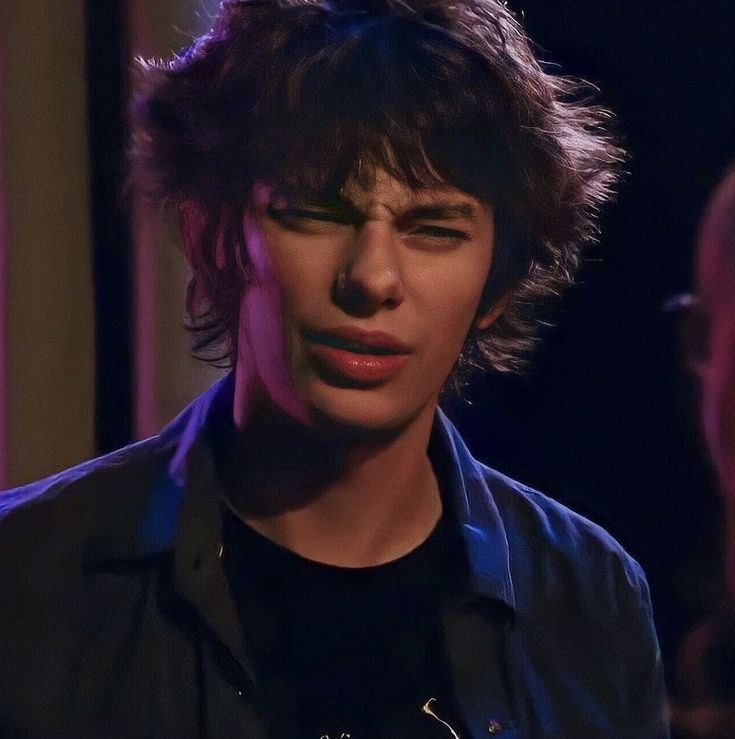 a close up of a person wearing a black shirt and dark hair with his eyes closed