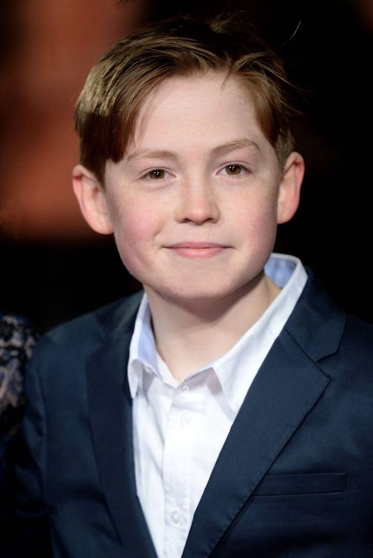 a young boy wearing a suit and white shirt