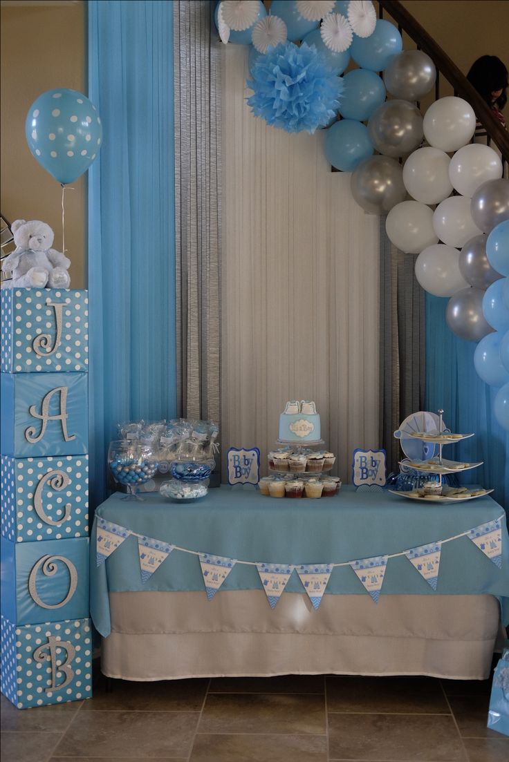 a blue and white dessert table with balloons