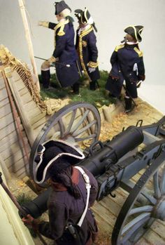 a group of men standing next to each other on top of a wooden platform near a cannon