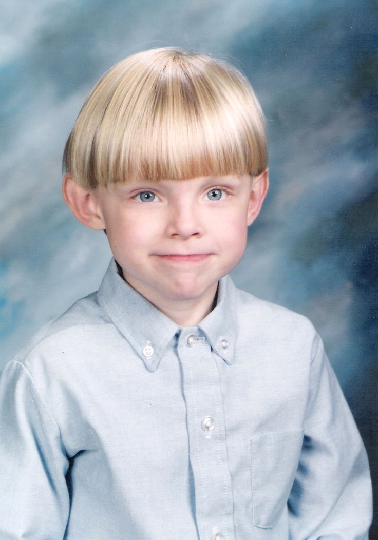 a young boy with blonde hair wearing a blue shirt