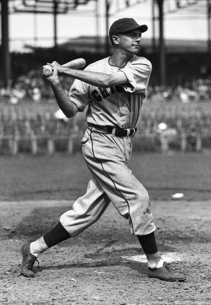 an old black and white photo of a baseball player swinging a bat at a ball