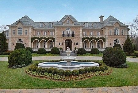 a large house with a fountain in the front yard