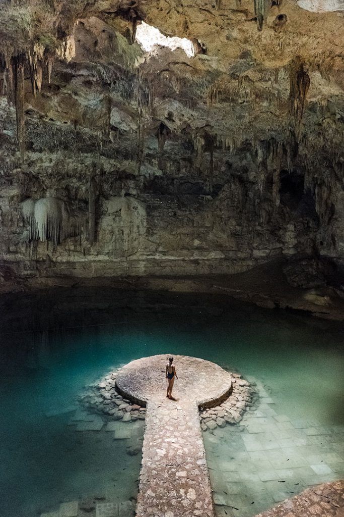 a person standing on a platform in a cave