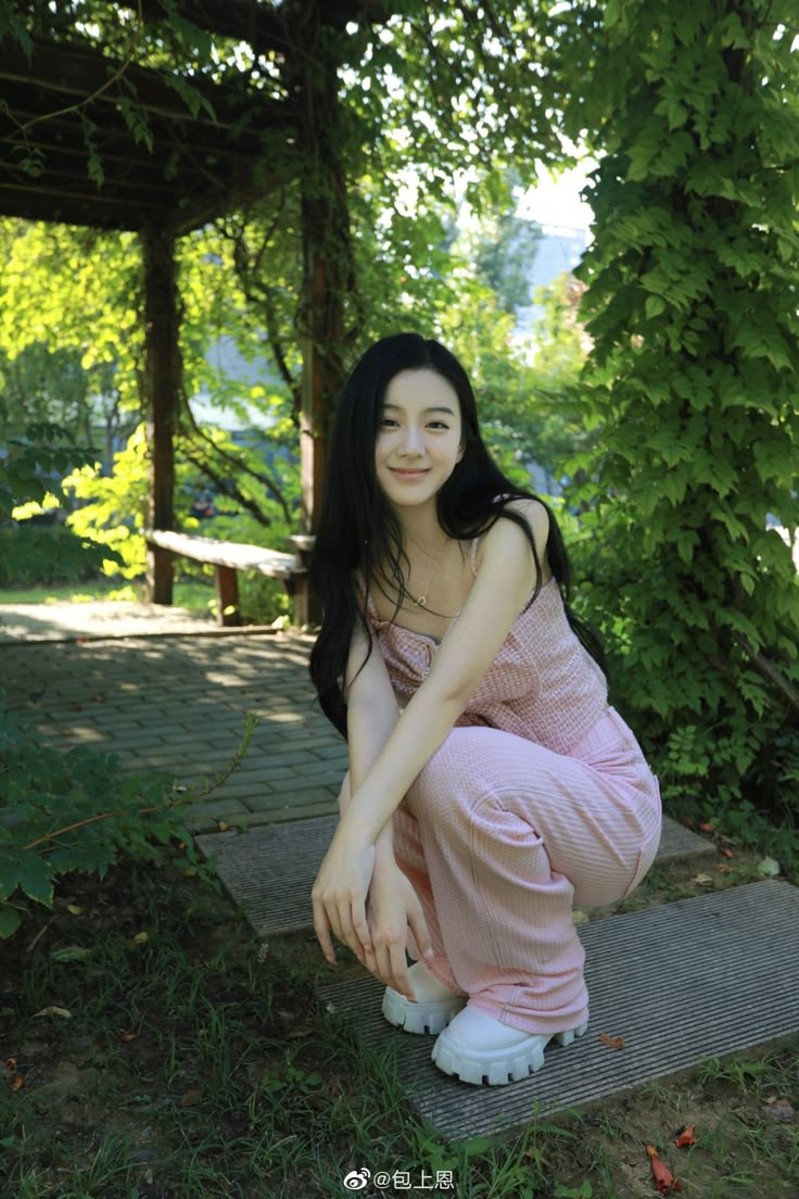 a woman in pink is sitting on the ground