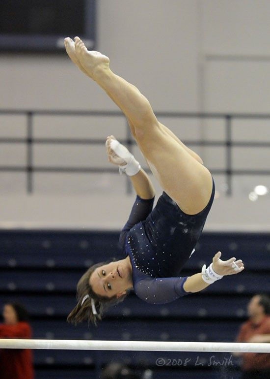 a woman is performing on the uneven bars