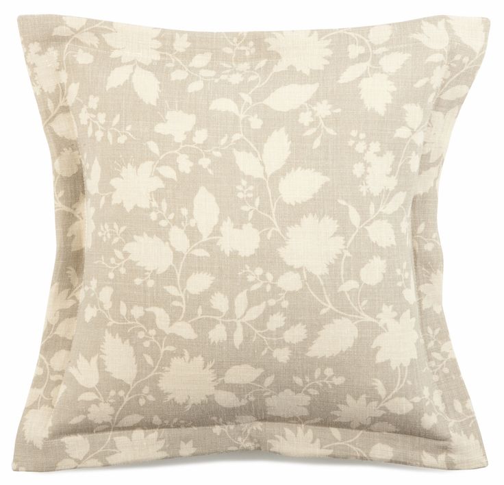 a white and beige pillow with flowers on it