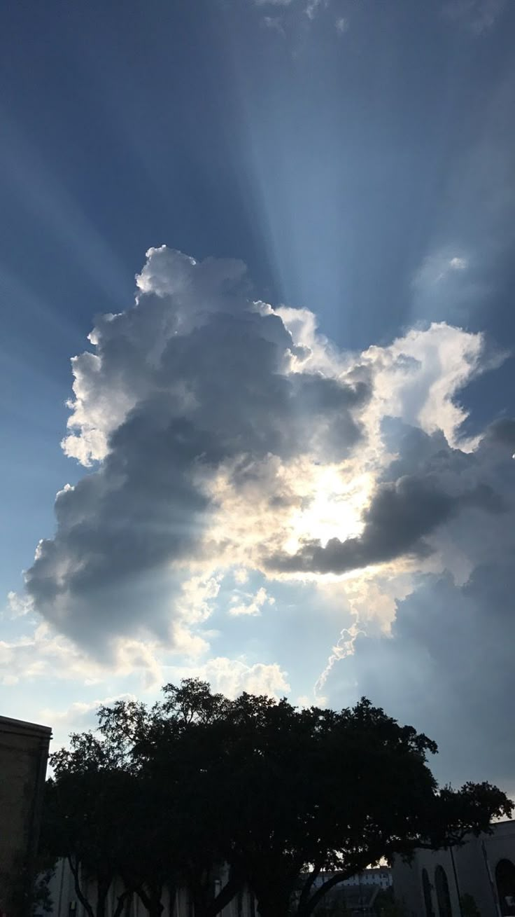 the sun shines brightly through clouds over a building