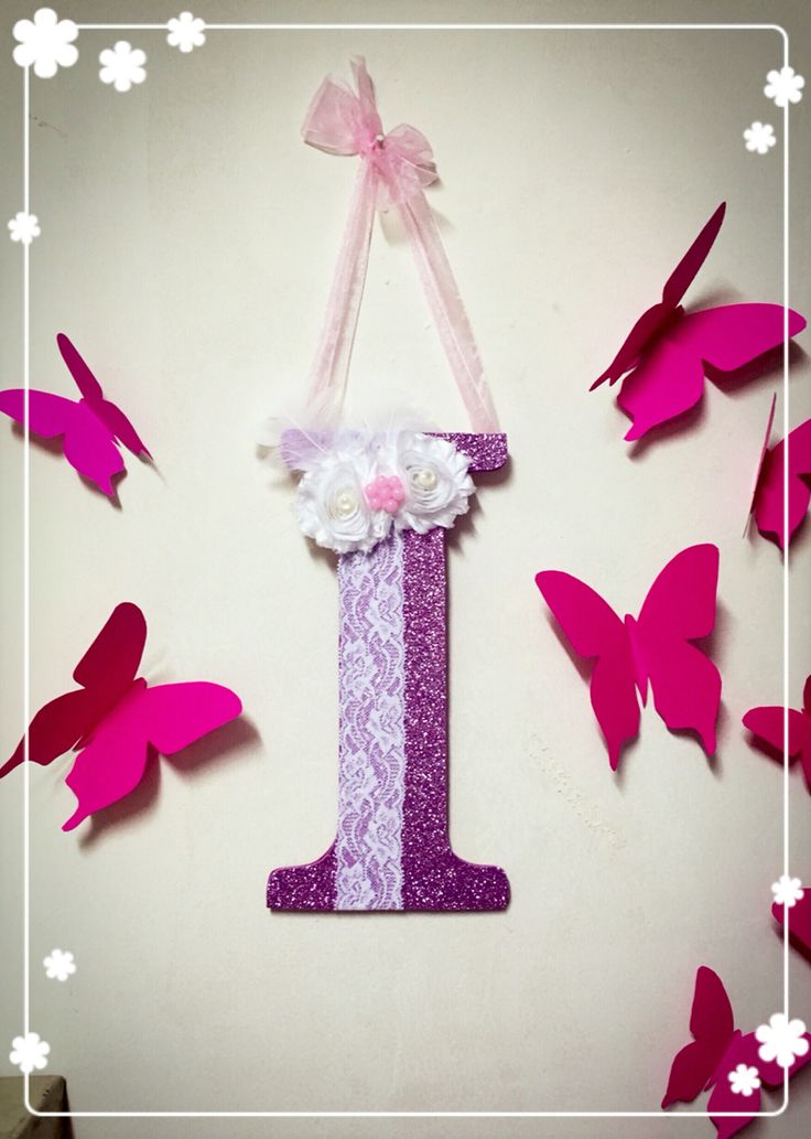 the number one is made out of paper with butterflies around it and pink flowers on top