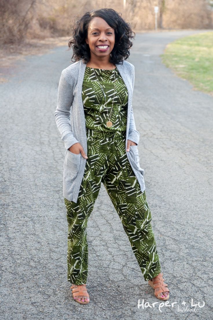 a woman standing in the middle of a road wearing green and white patterned jumpsuits