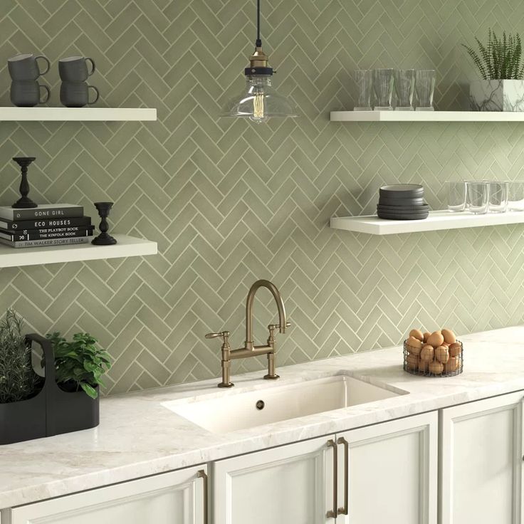 a kitchen with white cabinets and green tile backsplash, shelves above the sink