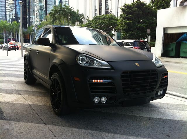 a black porsche cayen is parked on the street