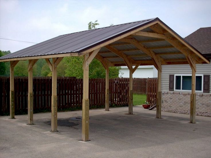 a large wooden carport sitting in the middle of a driveway