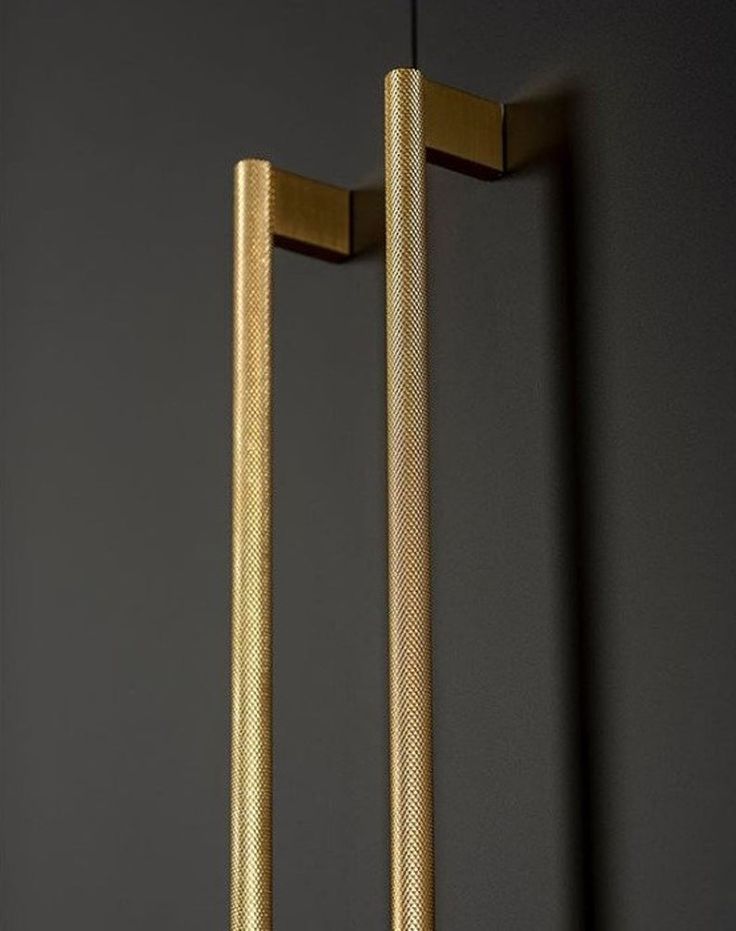 two gold handles are hanging on the wall