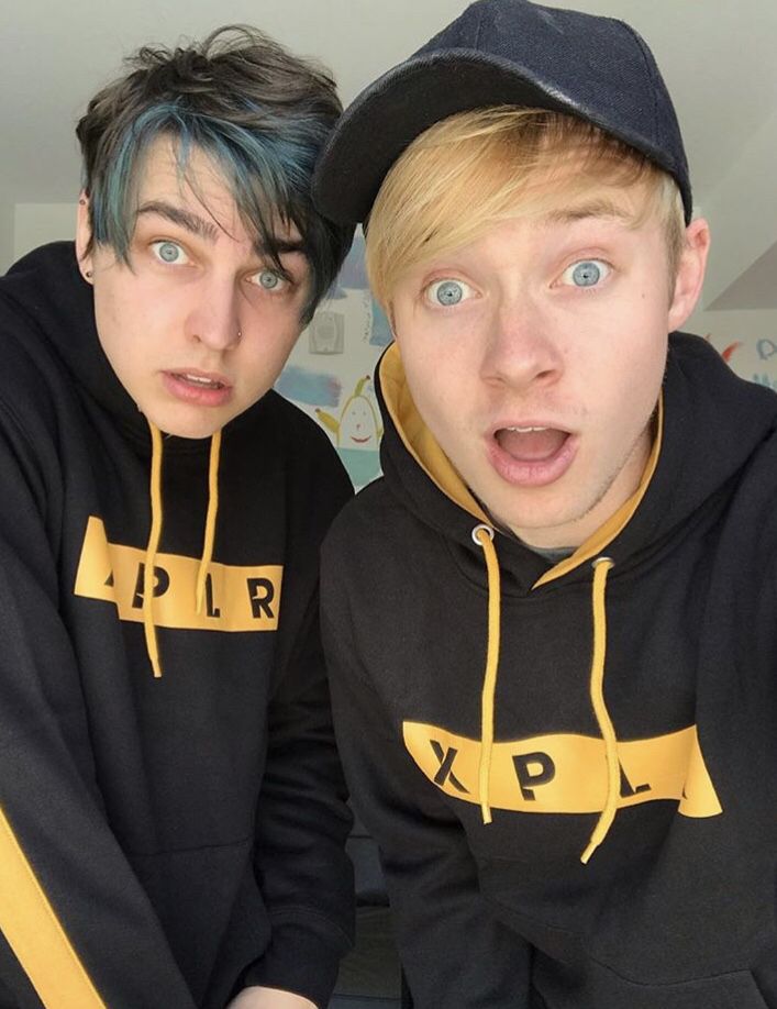 two young men in matching sweatshirts posing for the camera with their mouths wide open