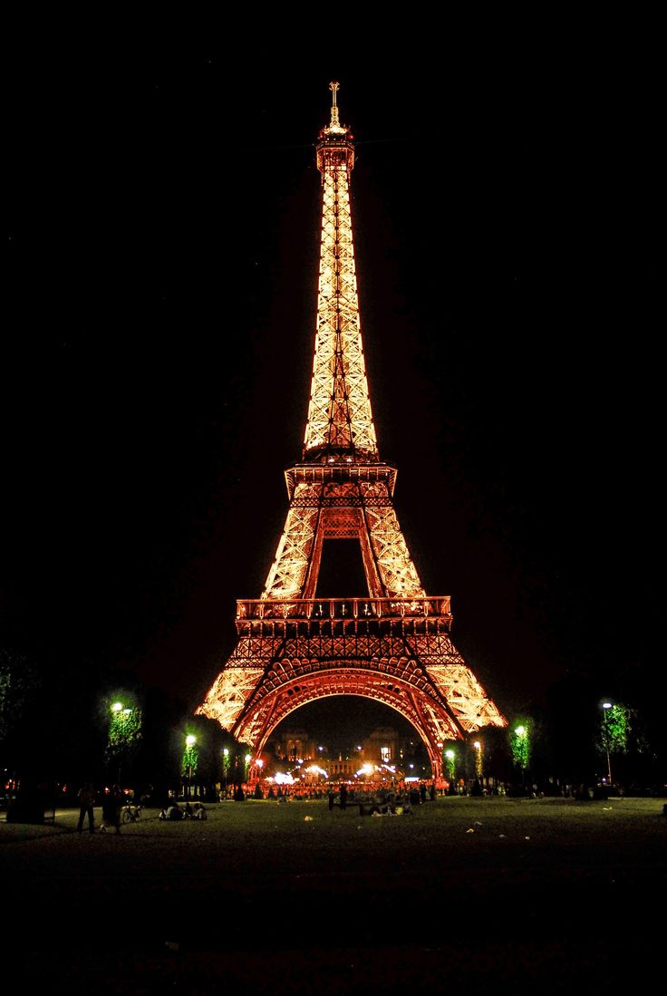 the eiffel tower is lit up at night