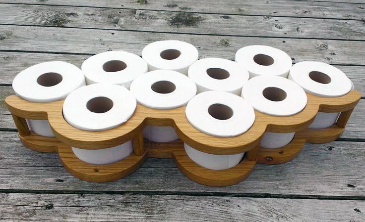 several rolls of toilet paper stacked on top of each other in a wooden holder with wheels