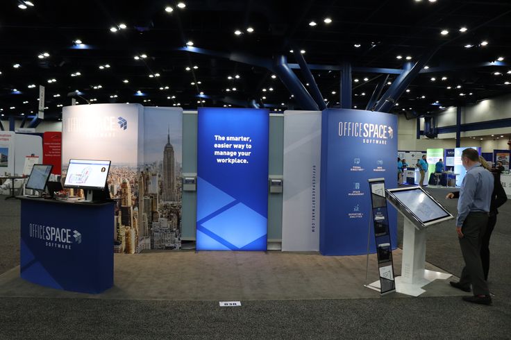 a man standing in front of a podium at a trade show with information on it