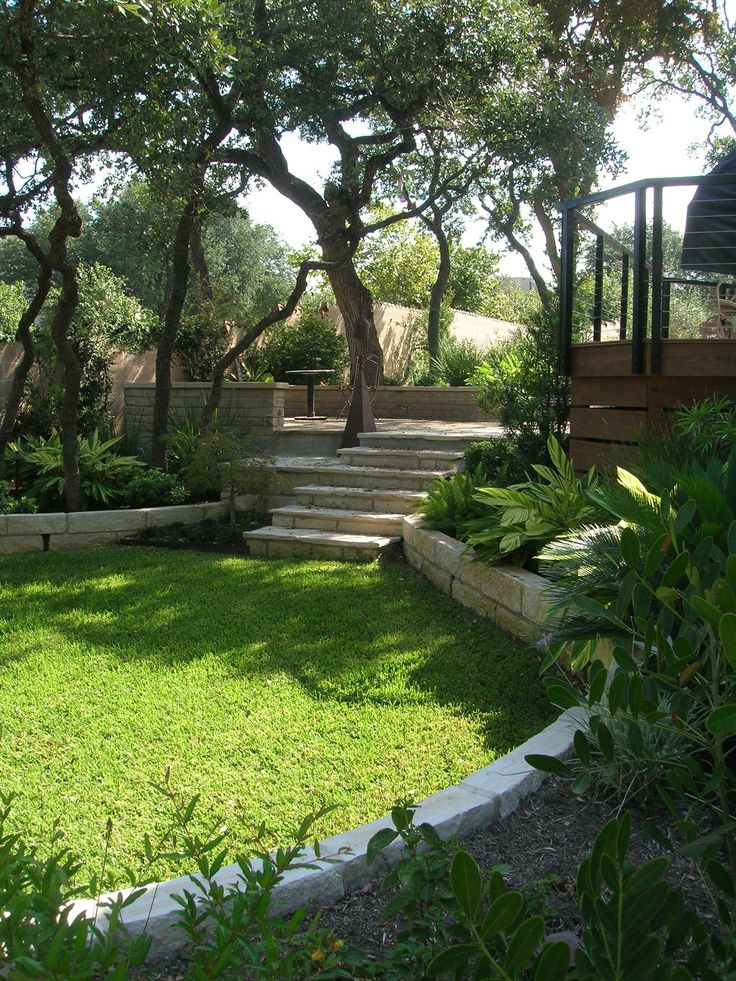 a lush green yard with stairs and trees