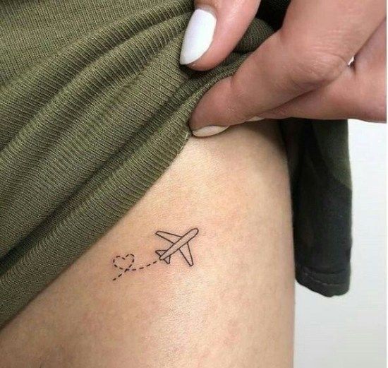 a woman's leg with a small airplane tattoo on the back of her thigh