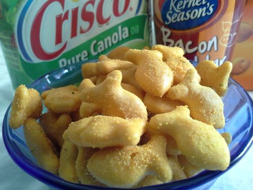 a blue bowl filled with fried food next to two cans of crispo seasoning