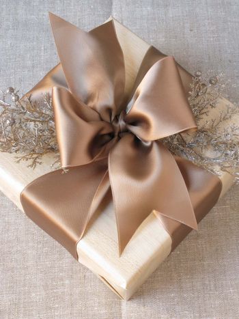 a gift wrapped in brown paper with a bow