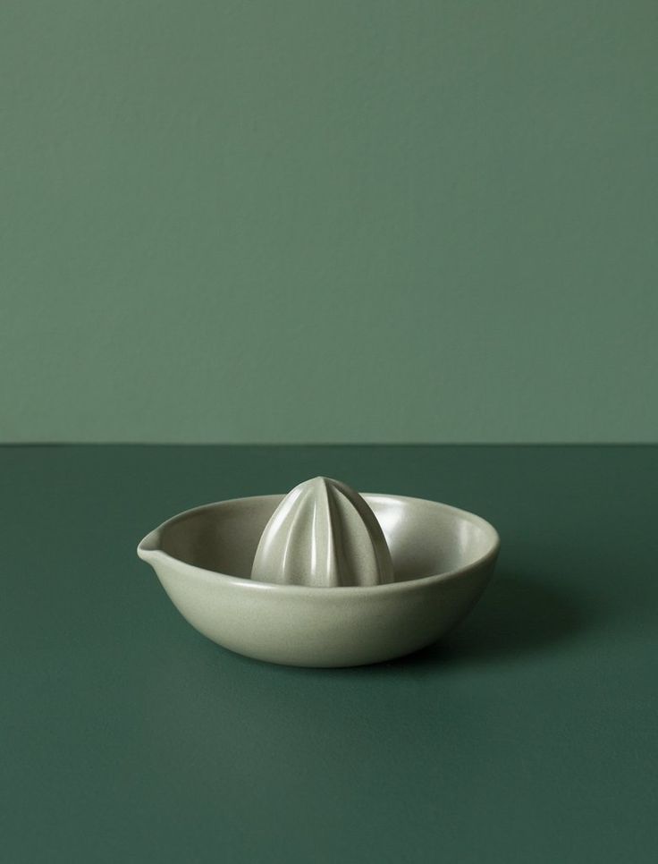 a white bowl sitting on top of a green table