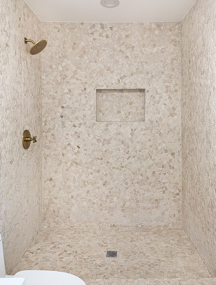 a white toilet sitting next to a shower in a bathroom under a skylight with no curtains