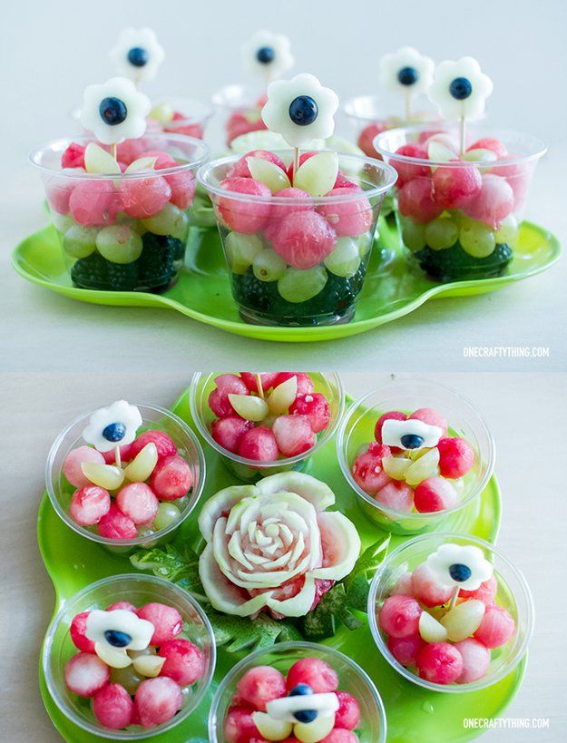 there are many small cupcakes with flowers in them on the green platter