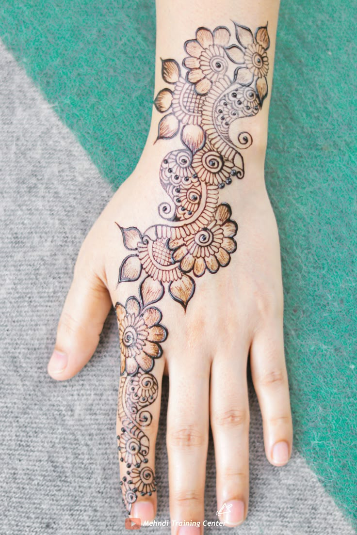 a woman's hand with henna tattoos on it