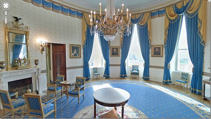 the oval room is decorated with blue curtains and gold trimmings, along with ornate furniture