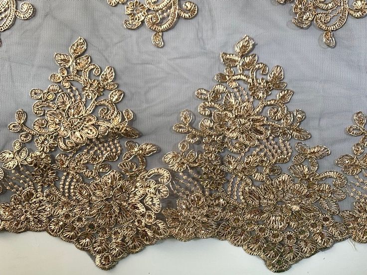 Brianna GOLD Polyester Floral Embroidery with Sequins on BLACK Mesh Lace Fabric by the Yard - 10020 Stand out magnificently as you gracefully appear wearing this stunning lace fabric. Intricate embroidery adorns this fabric, with some sequins scattered all throughout, giving it a lavish and regal feel. Content: 100% polyester Stretch: Minimal to none Width: 50 to 52 inches Edge: Scalloped on both edges Uses: Wedding dress, evening gown, formal wear, tops, skirts, costumes, crafts, etc. DISCLAIME Elegant Gold Embroidered Fabric With Lace Work, Gold Embroidered Fabric For Formal Occasions, Elegant Gold Embroidered Fabric For Formal Wear, Fitted Gold Embroidered Fabric With Intricate Details, Fitted Gold Fabric With Intricate Embroidery, Fitted Gold Embroidered Fabric In Elegant Style, Elegant Gold Embroidered Fitted Fabric, Elegant Fitted Gold Embroidered Fabric, Elegant Gold Resham Embroidered Fabric