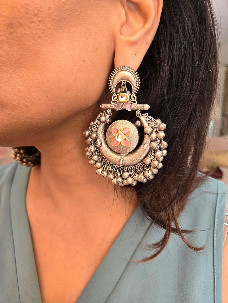 Statement silver boho ghungroo Kundan chandbaali earrings for a stunning look. Perfect for adding a unique and stylish touch to any outfit. Earring Dimensions:  Approximately 3.2 Inches Long  Approximately 2 Inches Wide  A Earring Weight is 1.3 oz All our products are crafted using traditional skills from our rich heritage. The manual nature of these crafts means that irregularities or variations are inherent in the handcrafting process. Silver Temple Jewelry Chandelier Earrings With Latkans, Festive Silver Chandelier Earrings With Tilla, Traditional Silver Chandelier Earrings For Festive Occasions, Metal Chandbali Bridal Earrings, Metal Chandbalis With Meenakari, Silver Tilla Jhumkas For Festival, Traditional Oxidized Chandelier Earrings For Festive Occasions, Festive Fusion Hoop Earrings, Festive Fusion Style Hoop Earrings