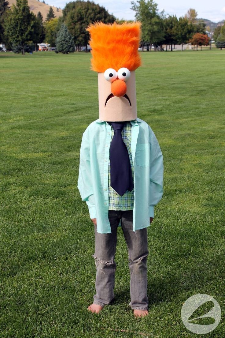 a person wearing an orange wig and tie standing in the middle of a grass field