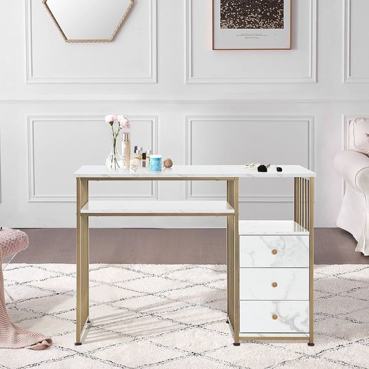 a white and gold desk with drawers on it in front of a wall mounted mirror