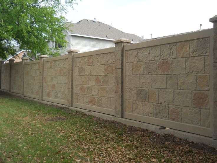 a stone fence in front of a house