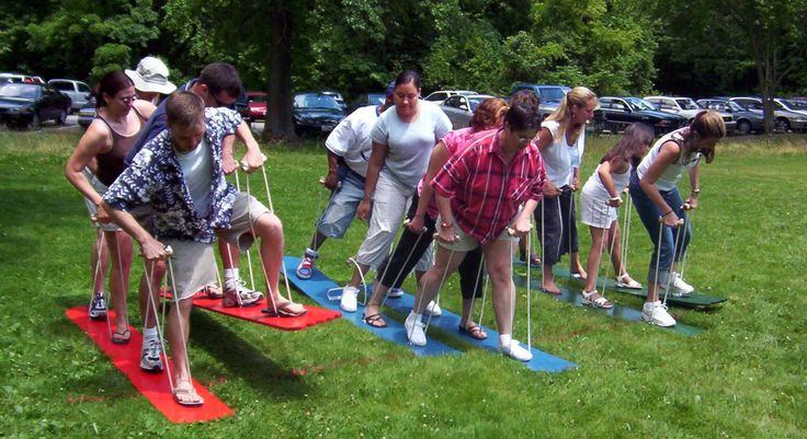 a group of people standing on top of red and blue surfboards in the grass