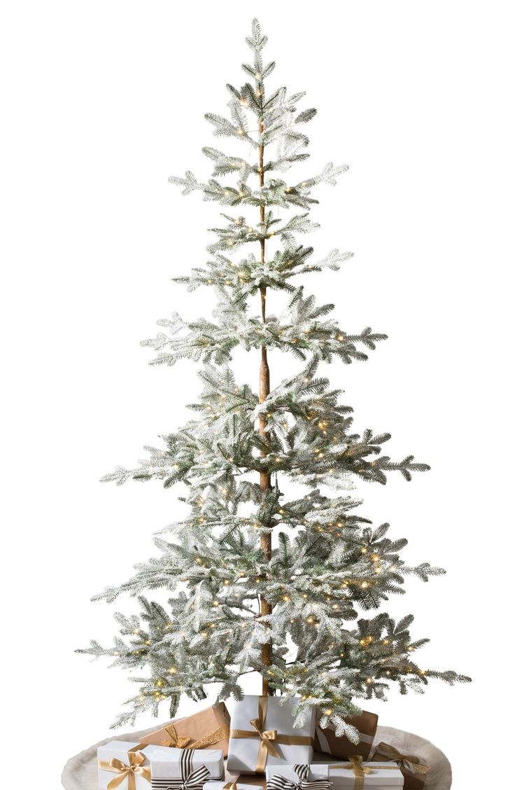 a small white christmas tree with presents under it on a platter in front of a white background