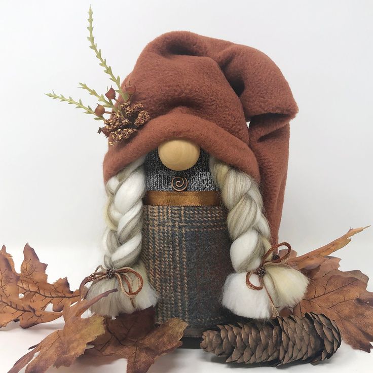 a nutcracker with a hat and scarf on it's head is surrounded by autumn leaves