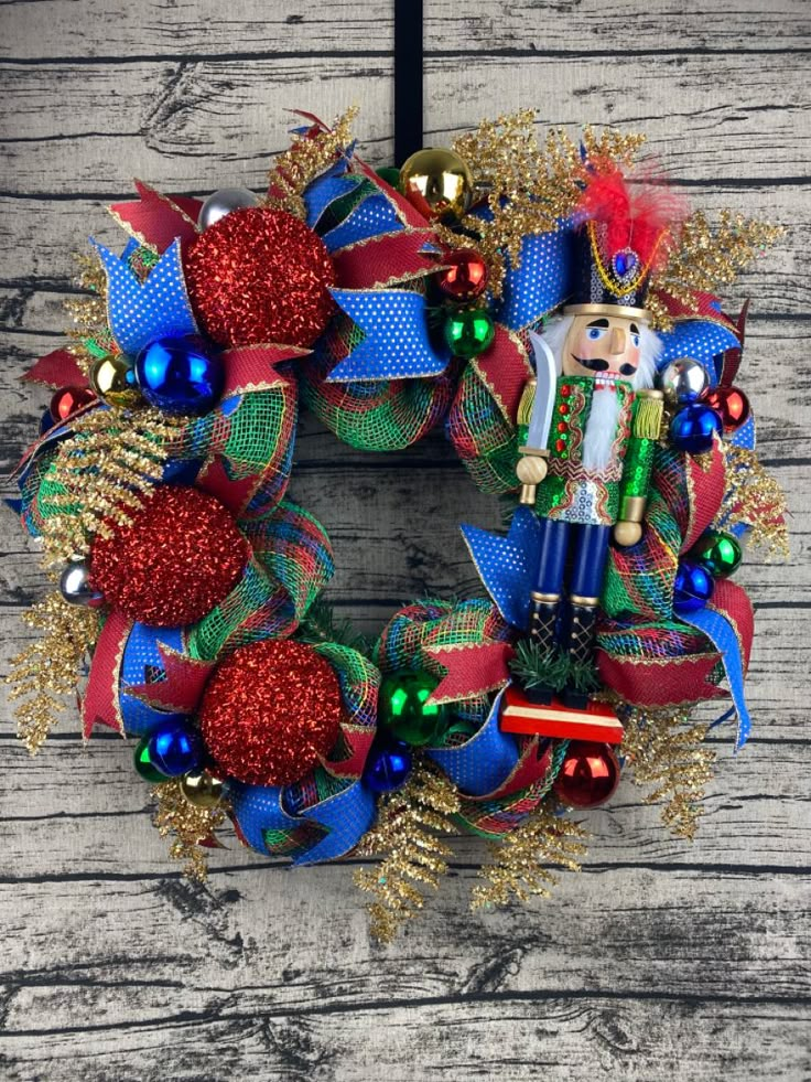 a wreath with a nutcracker on it sitting on top of a wooden table