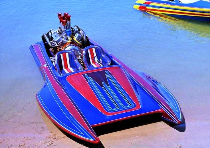 a red and blue boat sitting on top of a sandy beach