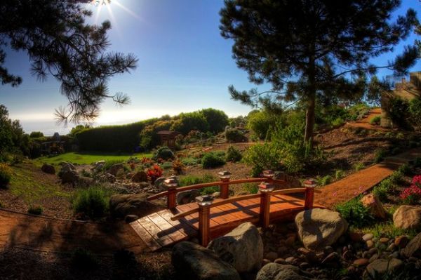 a small wooden bridge over rocks and flowers