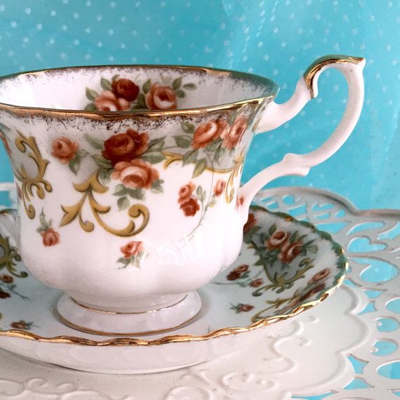 an antique tea cup and saucer on a doily