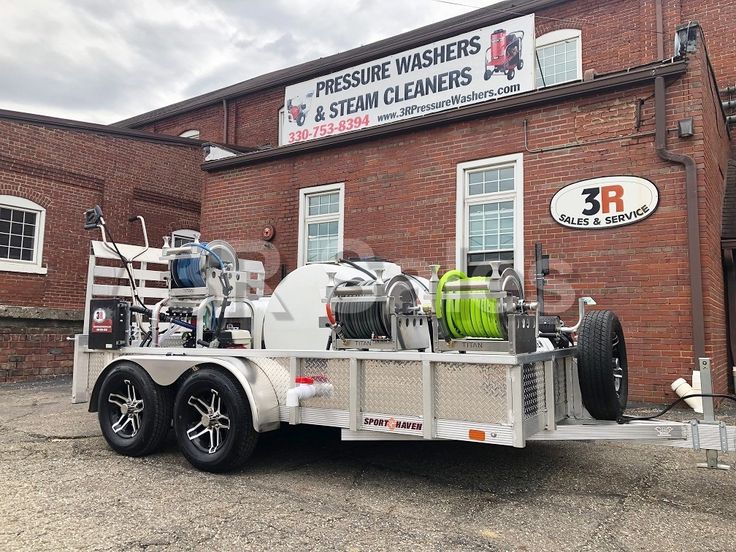 the trailer is parked in front of the building with its hoses attached to it