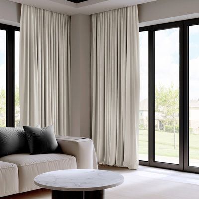 a living room with large windows and white curtains