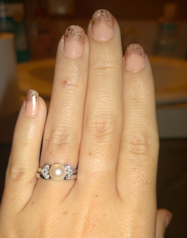 a close up of a person's hand with a ring on their finger and nails