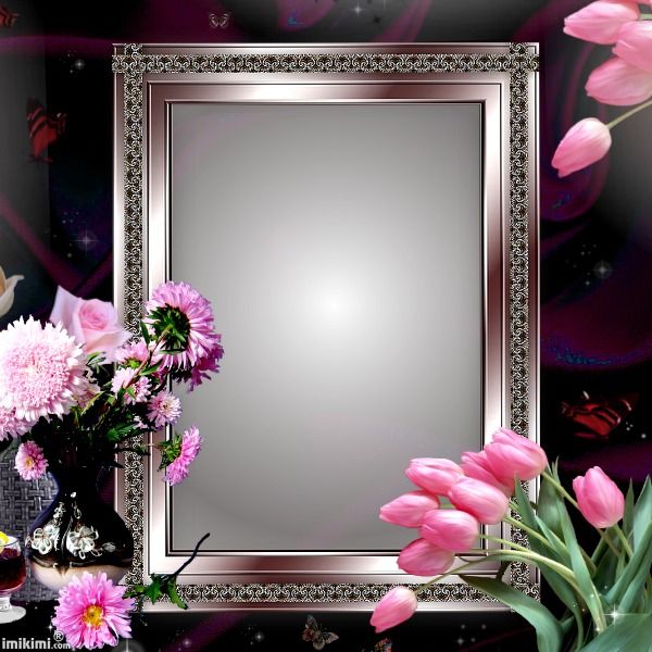 pink flowers are in vases next to a silver framed mirror on a black table