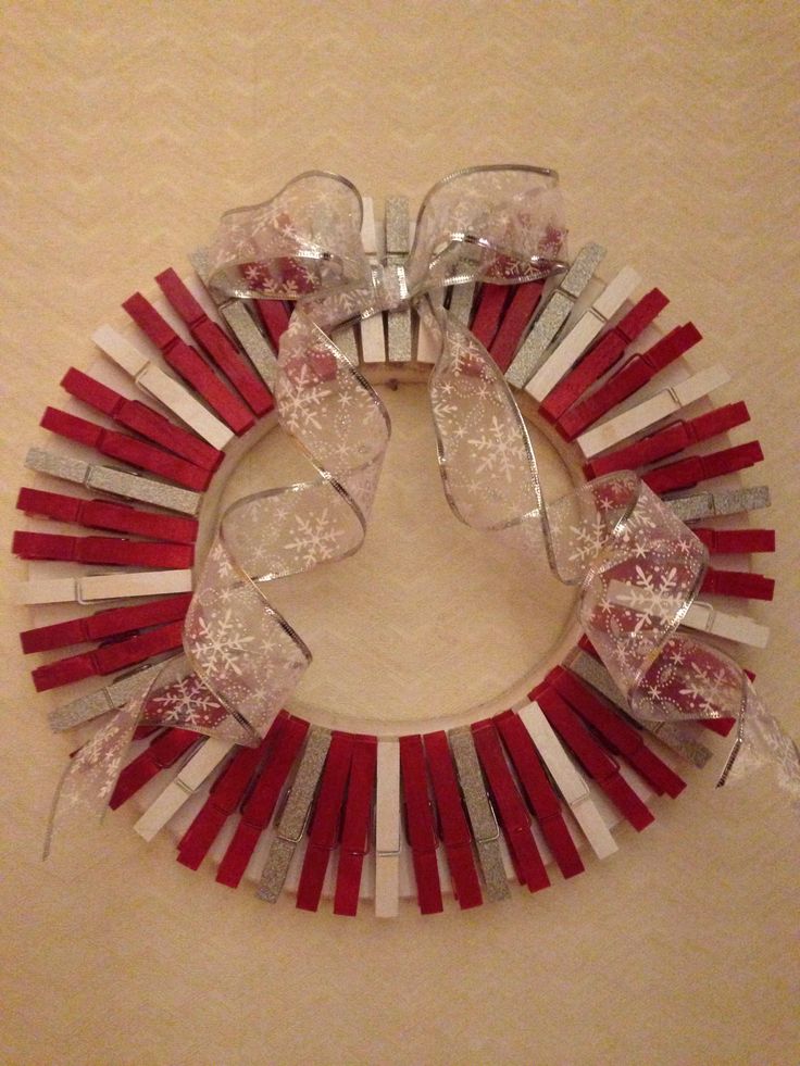 a red and white wreath made out of wine corks with glasses on the front